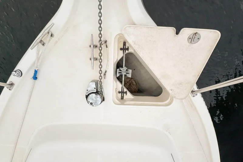 Slide: The Image of Bow of 2002 Pursuit 3000 Express boat with anchor chain and storage compartment. - 92