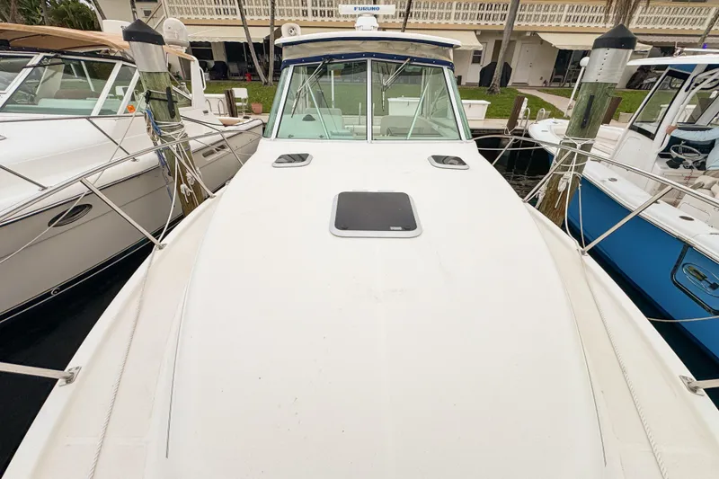 Slide: The Image of 2002 Pursuit 3000 Express boat docked, showcasing spacious deck and sleek design. - 95