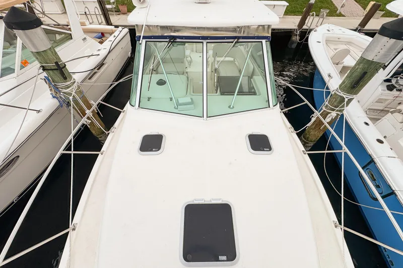 Slide: The Image of 2002 Pursuit 3000 Express boat docked, top view showing deck and windshield. - 96
