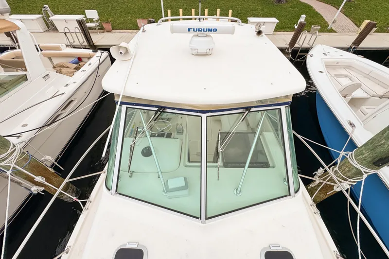 Slide: The Image of 2002 Pursuit 3000 Express boat docked, aerial view showing cabin and surrounding boats. - 99
