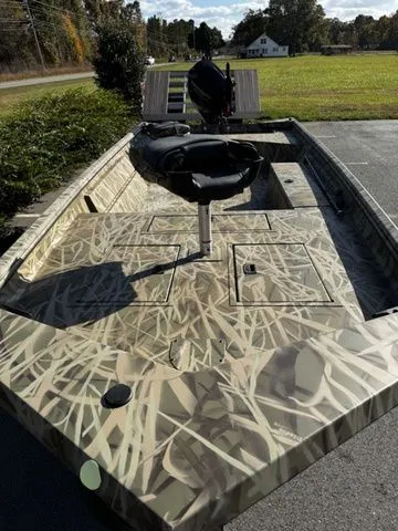 Slide: The Image of 2025 Crestliner 1860 Retriever Jon Deluxe boat with camouflage design, parked outdoors. - 8