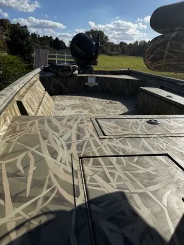 Slide: The Image of 2025 Crestliner 1860 Retriever Jon Deluxe boat with camouflage design, outdoor setting. - 7