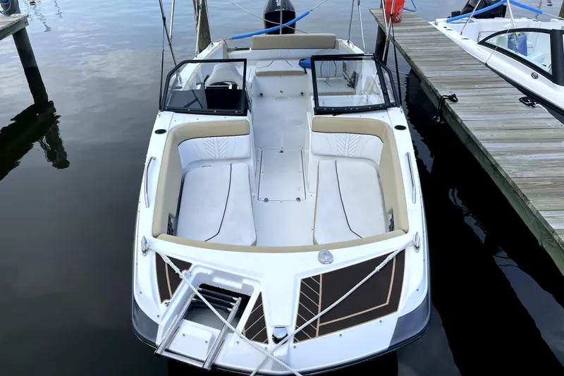 Slide: The Image of 2022 Glastron GTD 220 boat docked, featuring spacious seating and sleek design. - 2