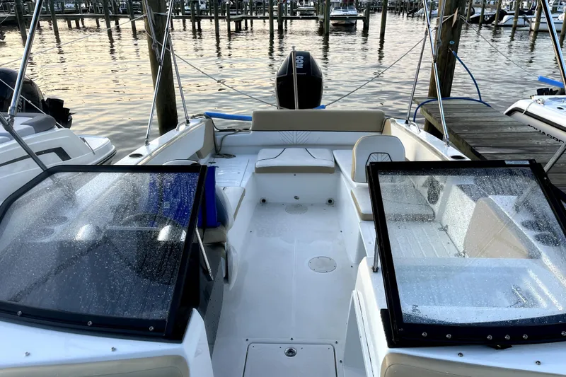 Slide: The Image of 2022 Glastron GTD 220 boat docked at marina, featuring spacious seating and sleek design. - 3