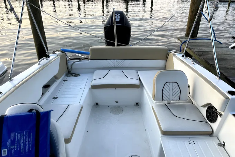 Slide: The Image of 2022 Glastron GTD 220 boat interior with seating, docked by the water. - 6