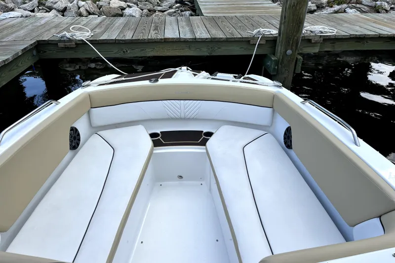 Slide: The Image of 2022 Glastron GTD 220 boat interior with beige and white seating at dock. - 7