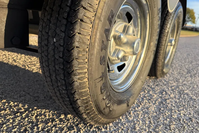 Slide: The Image of Close-up of 2018 Tracker Targa 18 WT trailer tires on a sunny day. - 14