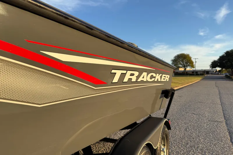 Slide: The Image of 2018 Tracker Targa 18 WT boat with Minn Kota PowerDrive motor, parked on grass. - 17