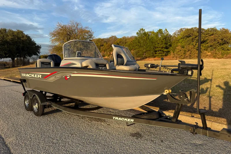 Slide: The Image of 2018 Tracker Targa 18 WT boat with Mercury engine on a trailer, parked outdoors. - 22