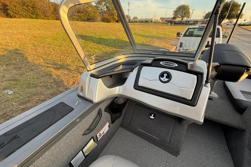 Slide: The Image of 2018 Tracker Targa 18 WT boat interior with steering wheel and dashboard, parked outdoors. - 54
