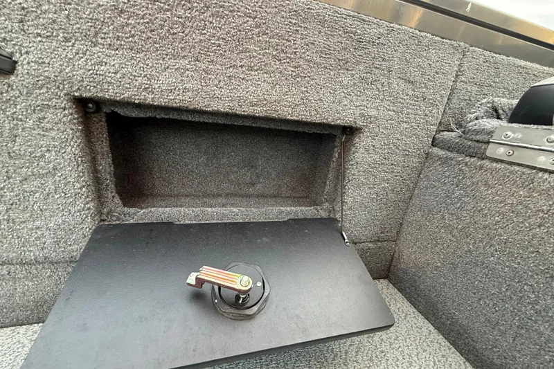 Slide: The Image of 2018 Tracker Targa 18 WT boat storage compartment with open hatch and latch mechanism. - 64