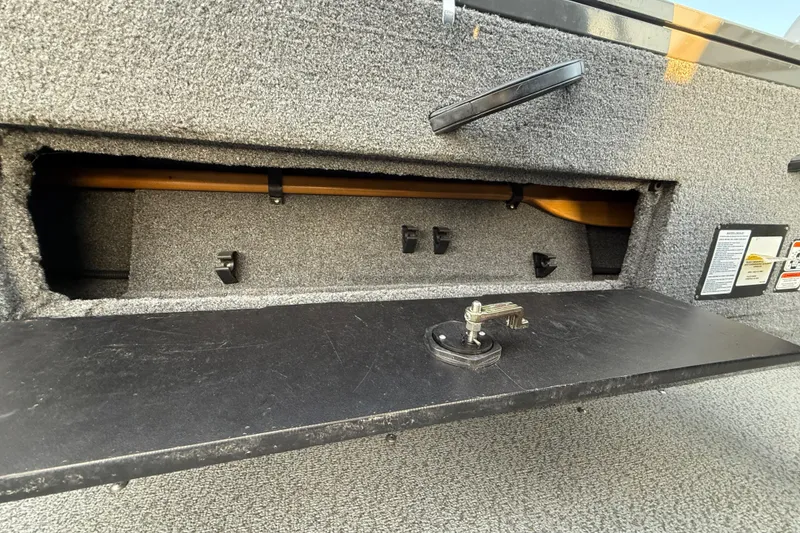 Slide: The Image of 2018 Tracker Targa 18 WT boat interior with seating and motor, parked on a street. - 67