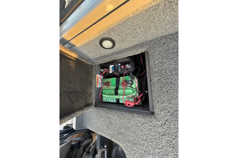 Slide: The Image of 2018 Tracker Targa 18 WT boat storage compartment, gray interior with carpeted edges. - 77