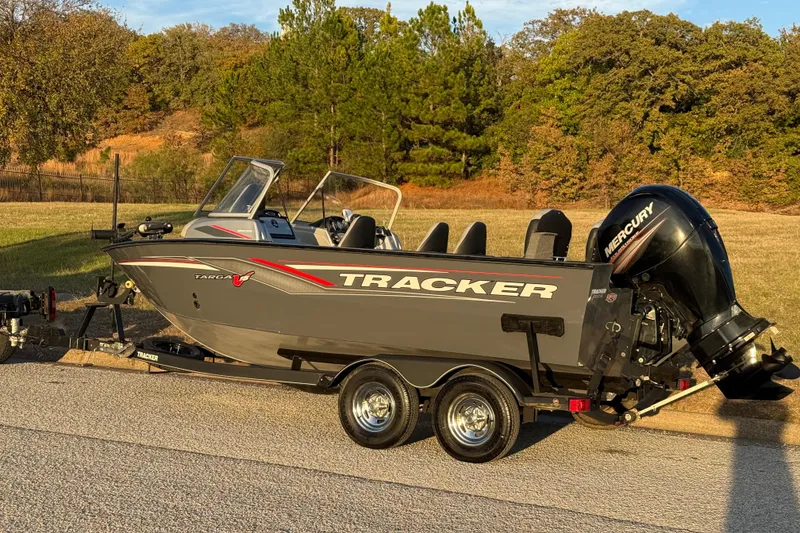 Slide: The Image of 2018 Tracker Targa 18 WT boat on trailer, parked on a road with trees in background. - 8