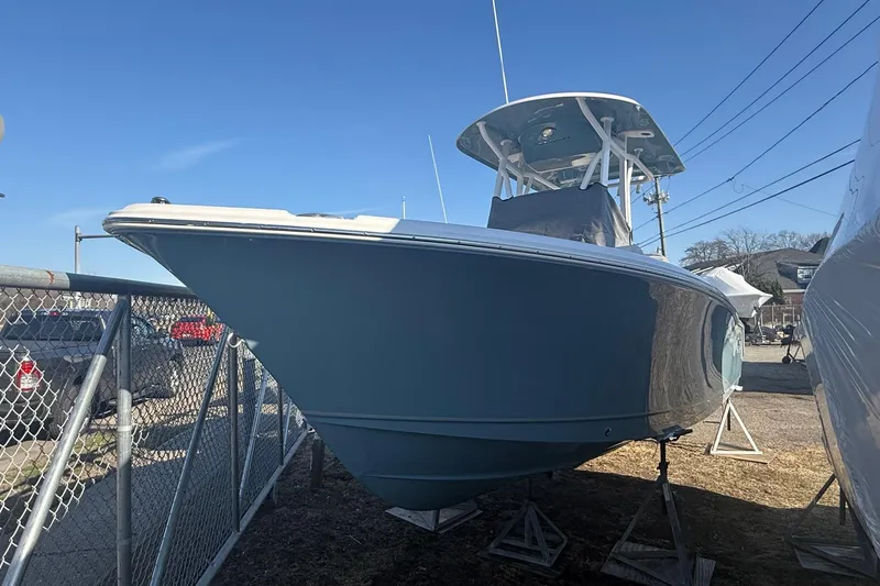 The Image of 2026 Sea Hunt Ultra 234 boat on display in a marina under clear blue sky. - 0