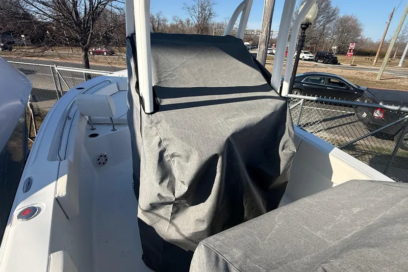 Slide: The Image of 2026 Sea Hunt Ultra 234 boat with covered console, parked outdoors. - 11