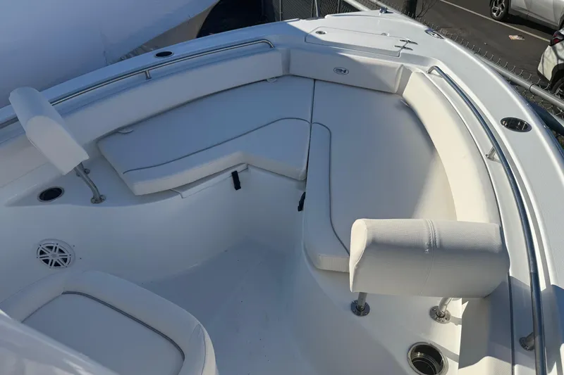 Slide: The Image of 2026 Sea Hunt Ultra 234 boat interior with white cushioned seating and stainless steel fixtures. - 20