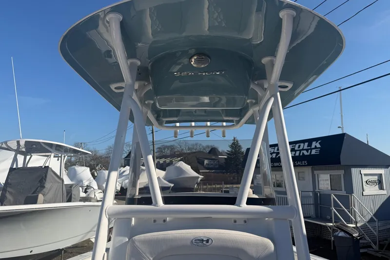Slide: The Image of 2026 Sea Hunt Ultra 234 boat with T-top, displayed at a marine dealership. - 22