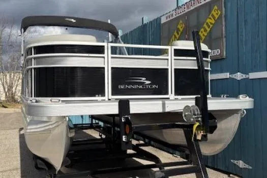 Slide: The Image of 2022 Bennington S 22 Quad Bench pontoon boat on trailer, outdoor display. - 2