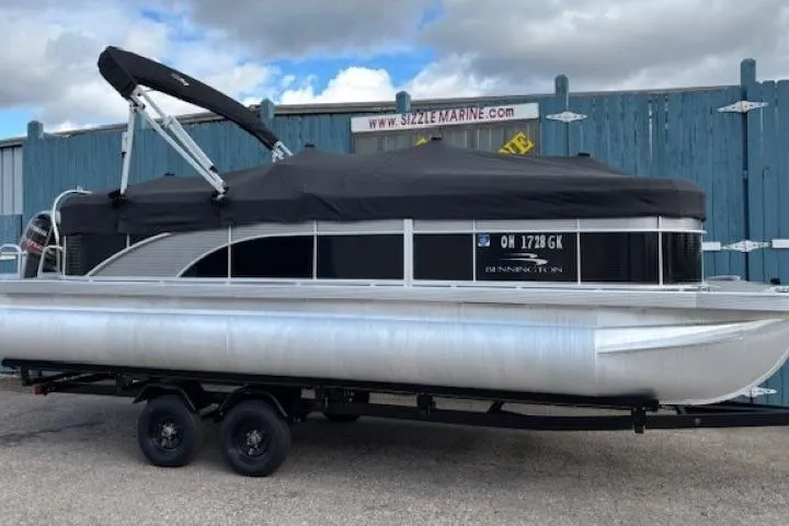 Slide: The Image of 2022 Bennington S 22 Quad Bench pontoon boat on trailer, covered and parked. - 32