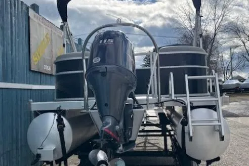 Slide: The Image of 2022 Bennington S 22 Quad Bench pontoon boat with 115 HP engine, docked outdoors. - 6