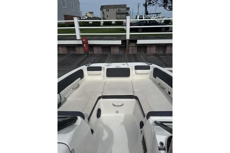 Slide: The Image of 2023 Bayliner DX 2200 boat interior with spacious seating at dock. - 5