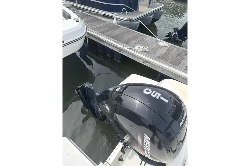 Slide: The Image of 2023 Bayliner DX 2200 with Mercury 150 outboard engine at dock. - 8