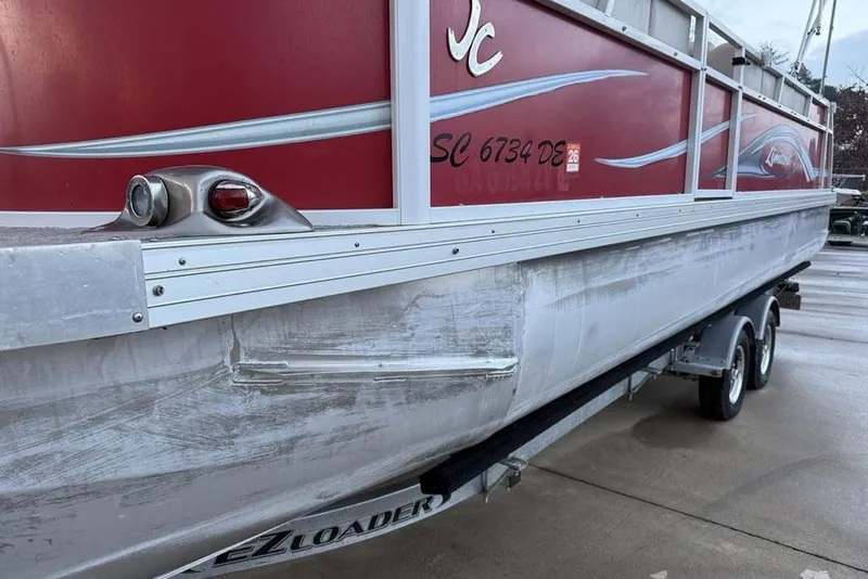 Slide: The Image of 2014 JC NepToon 24 Limited pontoon boat on trailer, red and silver design. - 2