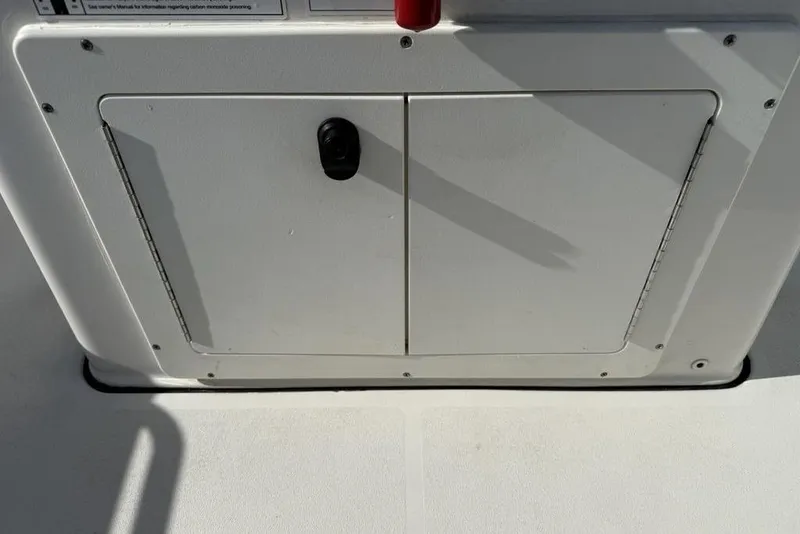 Slide: The Image of 2020 Sea Pro 172 Bay boat storage compartment with latch, white interior. - 21