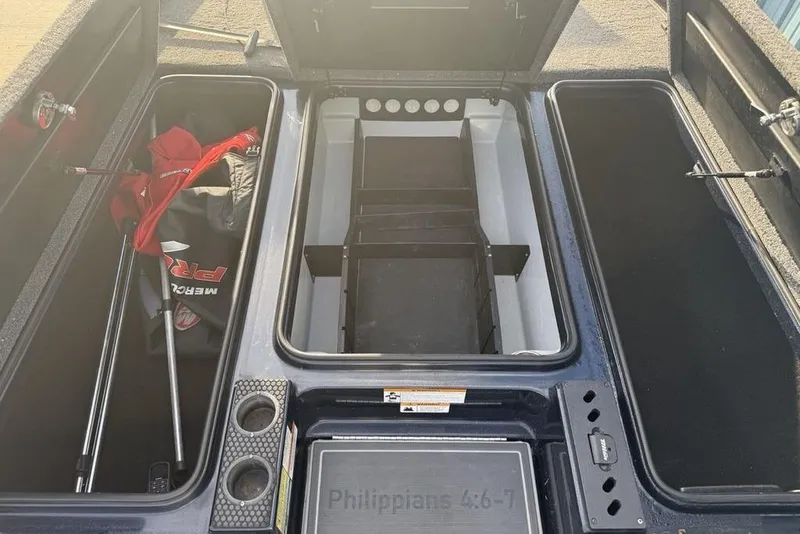Slide: The Image of 2021 Triton 21 TrX boat storage compartments with fishing gear and cup holders. - 12