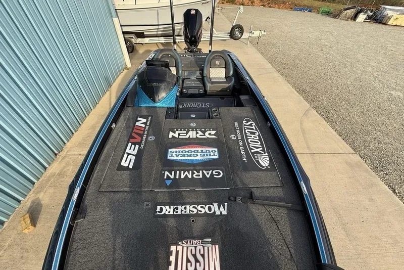 Slide: The Image of 2021 Triton 21 TrX fishing boat with sponsor logos, parked on concrete. - 22