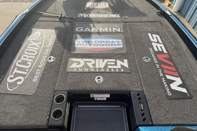 Slide: The Image of 2021 Triton 21 TrX boat deck with various brand logos and cup holders. - 8