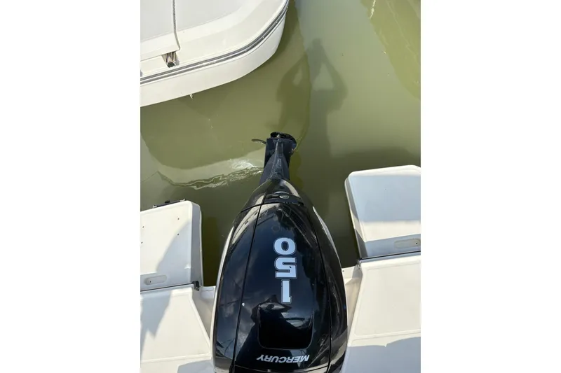 Slide: The Image of 2023 Bayliner DX 2200 with Mercury 150 outboard motor on calm water. - 7