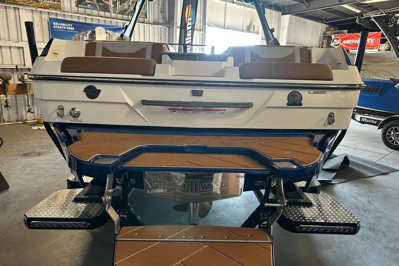 Slide: The Image of 2026 Malibu Wakesetter 23 LSV boat rear view in showroom setting. - 12