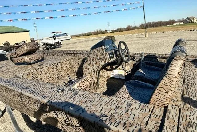 Slide: The Image of 2026 Express XP180 boat with camouflage design, featuring steering console and seating, displayed outdoors. - 3