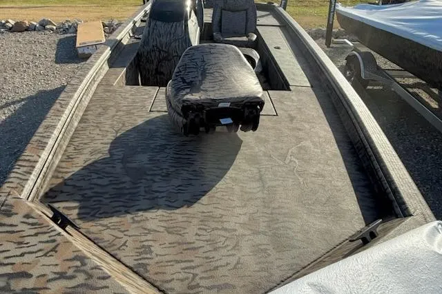 Slide: The Image of 2026 Express XP180 boat with camo interior, parked on gravel, showcasing spacious deck. - 6