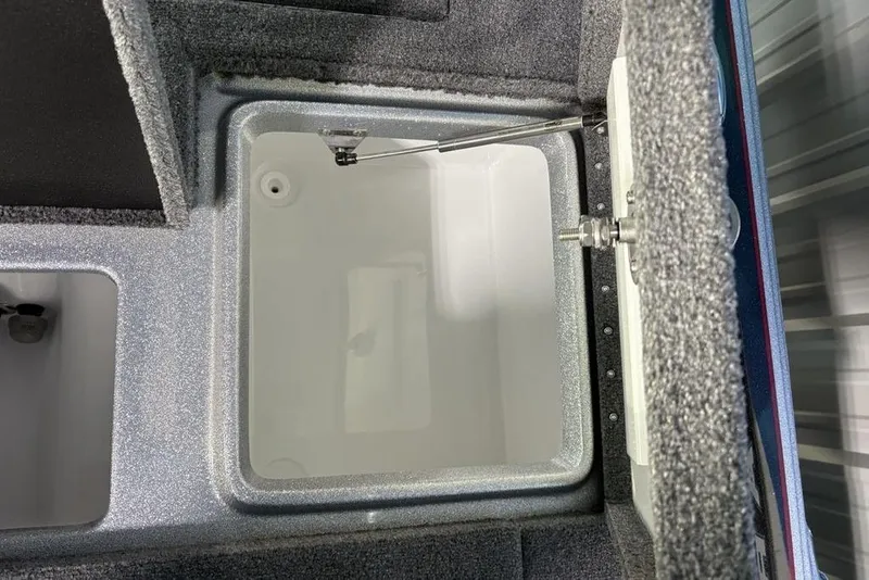 Slide: The Image of Open storage compartment in 2026 Phoenix 721 ZXL boat, featuring carpeted interior. - 26