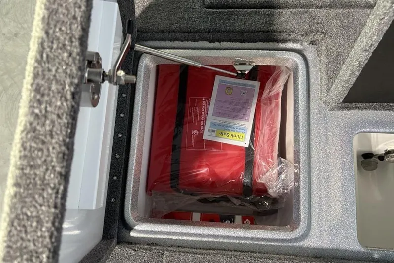 Slide: The Image of Storage compartment in a 2026 Phoenix 721 ZXL boat, containing safety equipment. - 28
