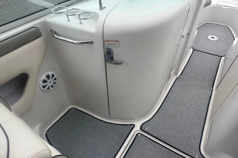 Slide: The Image of 2005 Sea Ray 270 Sundeck interior with cup holders and speaker, featuring gray carpet. - 13