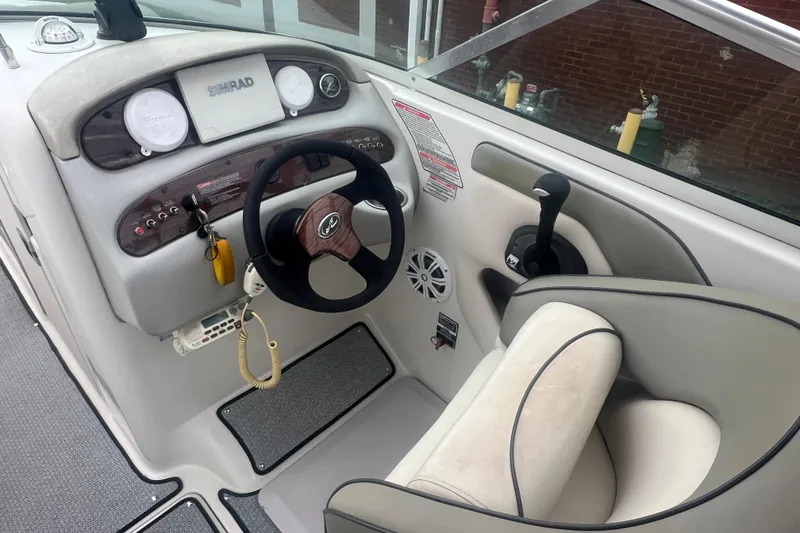 Slide: The Image of 2005 Sea Ray 270 Sundeck helm with steering wheel, controls, and Simrad display. - 14