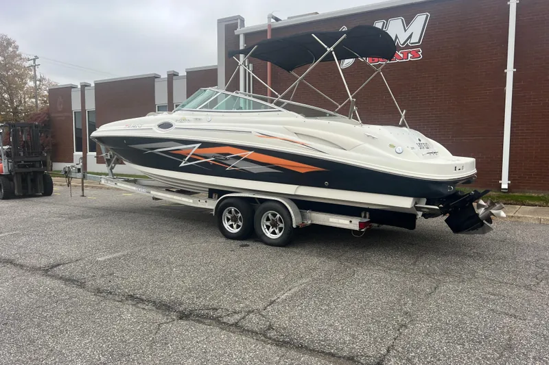 Slide: The Image of 2005 Sea Ray 270 Sundeck boat on trailer, parked outside a building. - 2