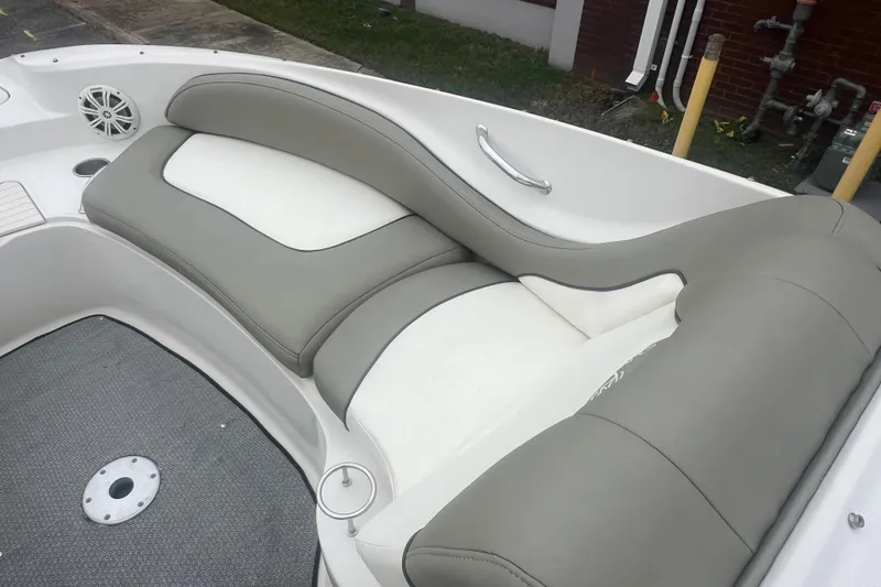 Slide: The Image of 2005 Sea Ray 270 Sundeck interior with gray and white seating, cup holder, and speaker. - 23