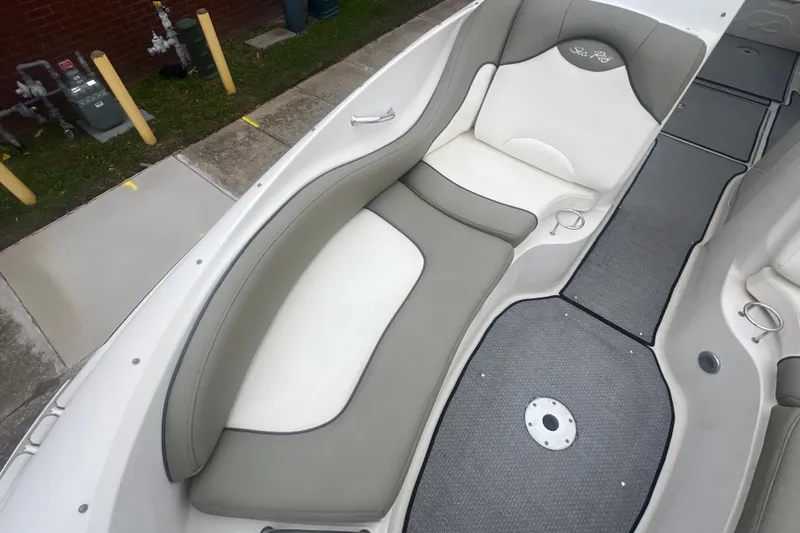 Slide: The Image of 2005 Sea Ray 270 Sundeck interior with cushioned seating and gray flooring. - 28