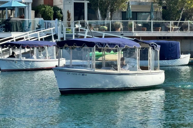 Slide: The Image of 2008 Duffy Snug Harbor boat with blue canopy cruising in a marina. - 3