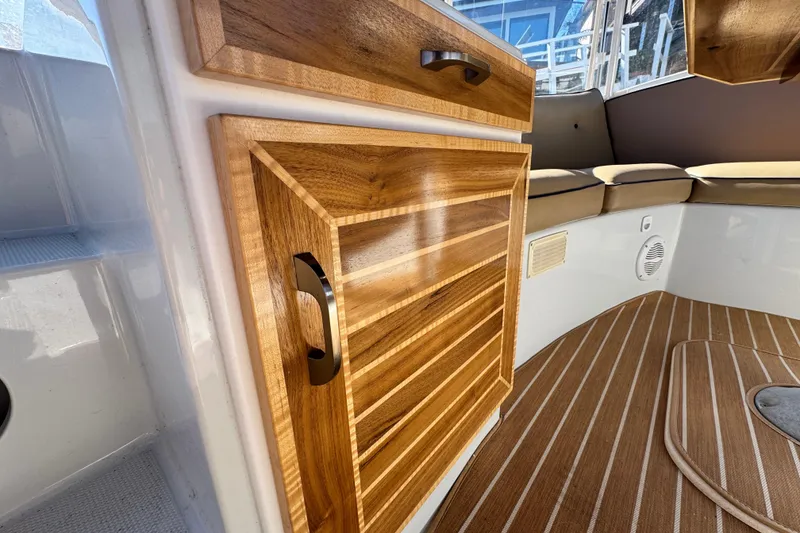 Slide: The Image of 2008 Duffy Snug Harbor boat interior with wooden cabinetry and cushioned seating. - 6