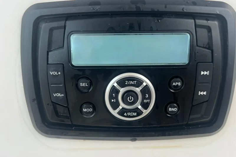 Slide: The Image of Boat stereo system on a 2013 Tidewater 216 CC Adventure, featuring control buttons and display. - 22