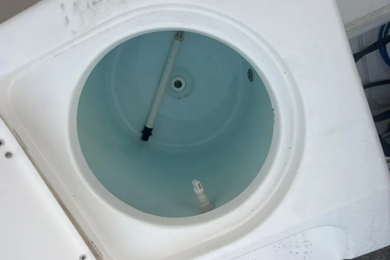 Slide: The Image of Livewell on 2013 Tidewater 216 CC Adventure boat, featuring clean interior and plumbing. - 34