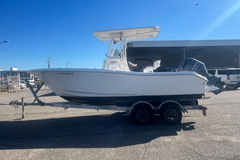 Slide: The Image of 2013 Tidewater 216 CC Adventure boat on trailer under clear blue sky. - 6