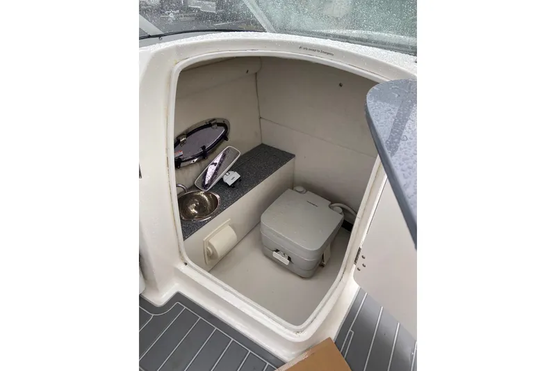 Slide: The Image of 2021 Chaparral 230 Suncoast boat interior with compact toilet and sink. - 15