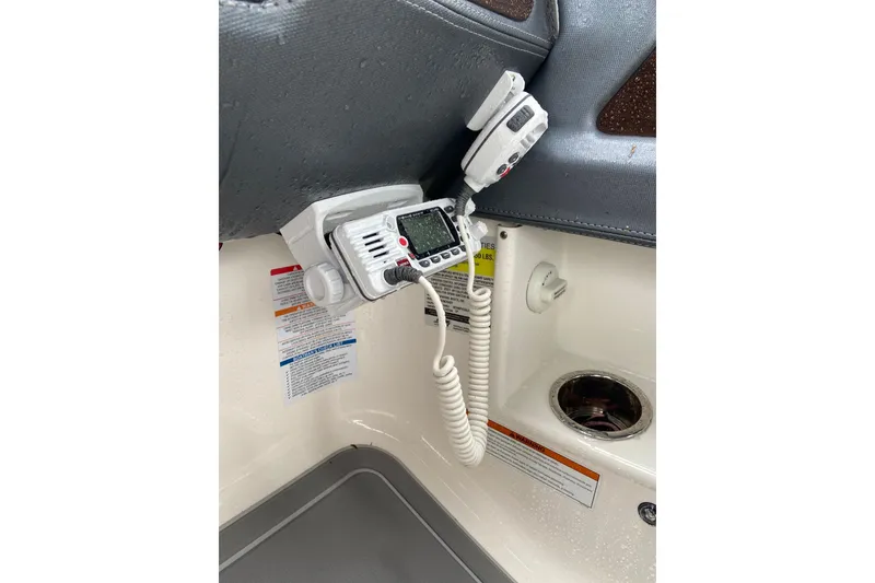 Slide: The Image of 2021 Chaparral 230 Suncoast boat interior with radio equipment and safety instructions. - 19